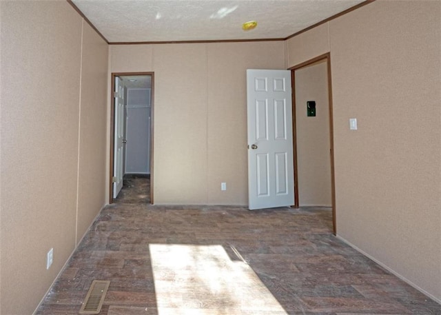 spare room featuring ornamental molding and a textured ceiling