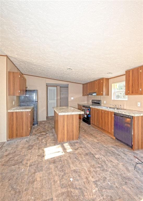 kitchen featuring sink, a textured ceiling, a kitchen island, black appliances, and light wood-type flooring