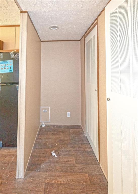 hall featuring a textured ceiling and dark hardwood / wood-style flooring