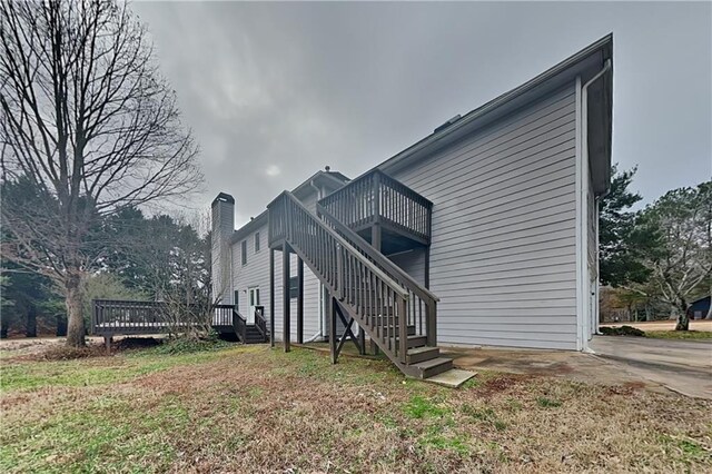 view of property exterior with a wooden deck and a lawn