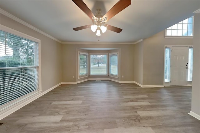 empty room with crown molding, light wood-type flooring, and ceiling fan