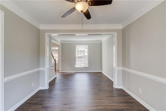 spare room featuring dark wood-type flooring, ceiling fan, stairway, and ornamental molding