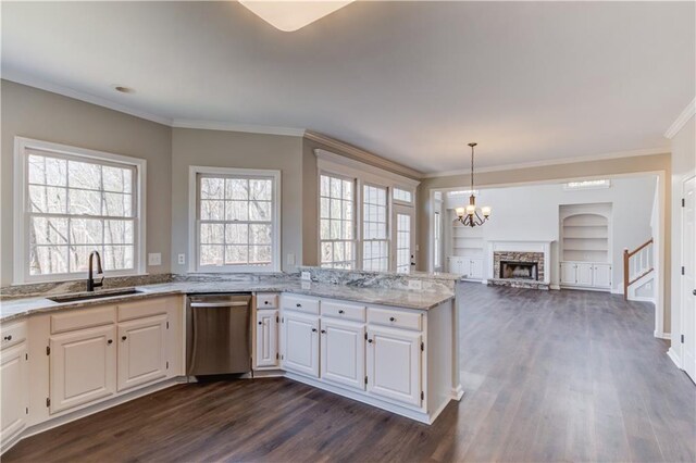 kitchen featuring white cabinetry, a sink, stainless steel dishwasher, and light stone counters