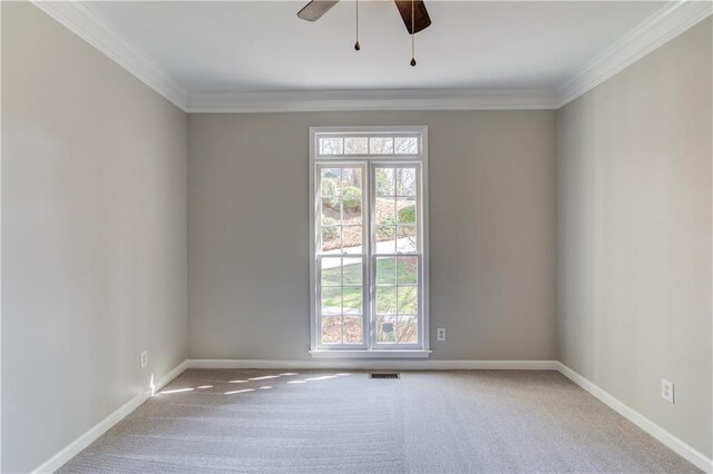 carpeted empty room featuring baseboards, visible vents, ceiling fan, and ornamental molding