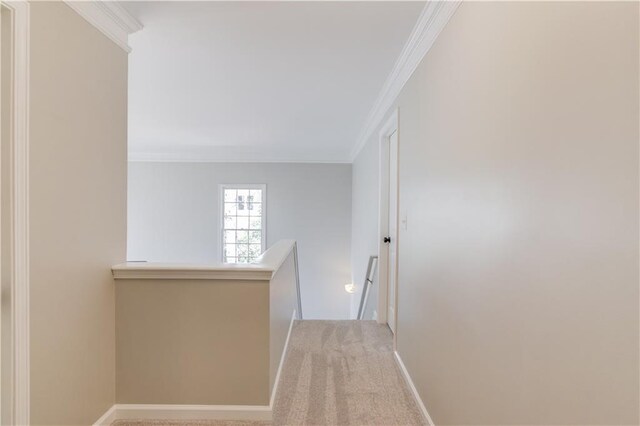 corridor featuring baseboards, an upstairs landing, carpet floors, and ornamental molding