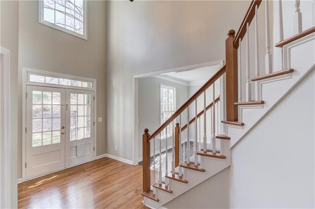 foyer entrance featuring plenty of natural light, stairs, and wood finished floors