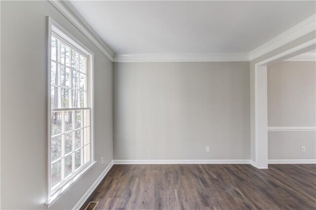 empty room with dark wood-style flooring, crown molding, and plenty of natural light