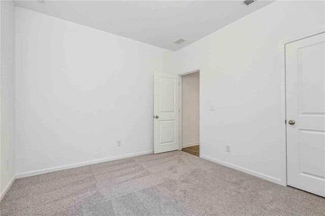 unfurnished room featuring light colored carpet