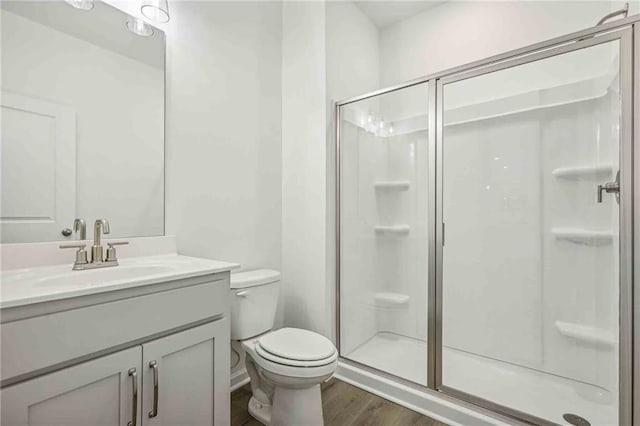 bathroom with vanity, toilet, wood-type flooring, and walk in shower