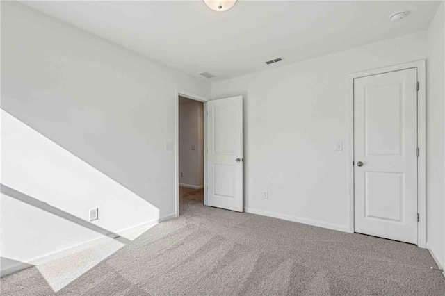 unfurnished room featuring light colored carpet