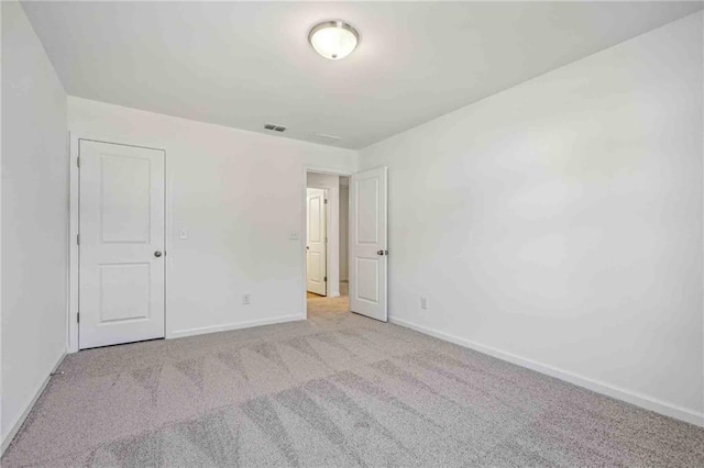 spare room featuring light colored carpet