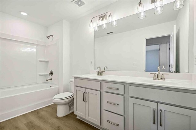 full bathroom featuring vanity, toilet, wood-type flooring, and shower / tub combination