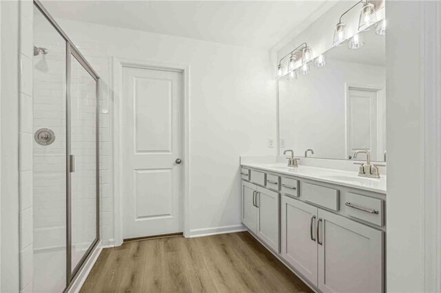 bathroom featuring wood-type flooring, vanity, and a shower with door