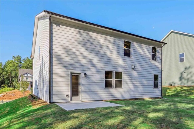 rear view of property with a yard and a patio area