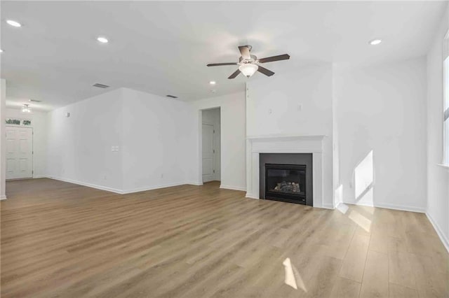 unfurnished living room featuring ceiling fan and light wood-type flooring