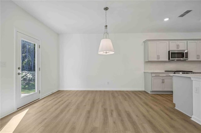 kitchen featuring pendant lighting, light wood-type flooring, and gray cabinets