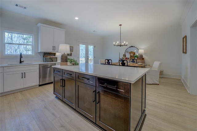 kitchen with dishwasher, a sink, light countertops, healthy amount of natural light, and recessed lighting