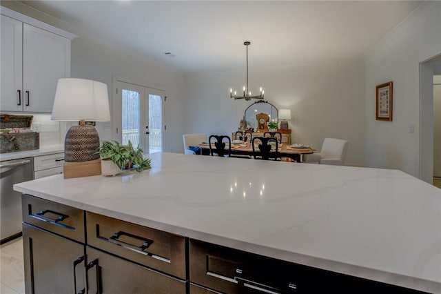 kitchen featuring light stone counters, dishwasher, french doors, decorative light fixtures, and white cabinets