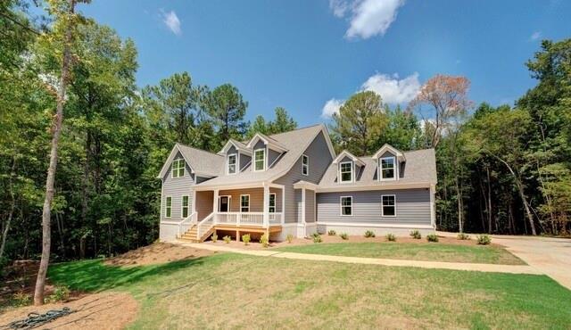 cape cod-style house featuring a porch and a front yard