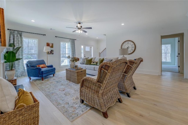 living area featuring healthy amount of natural light, light wood-type flooring, a ceiling fan, recessed lighting, and baseboards