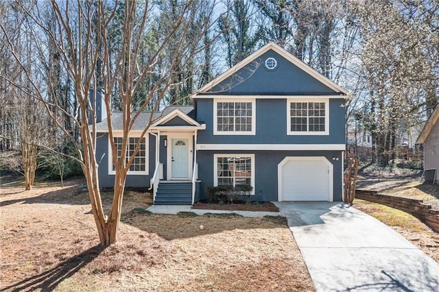 tri-level home with driveway, an attached garage, and stucco siding