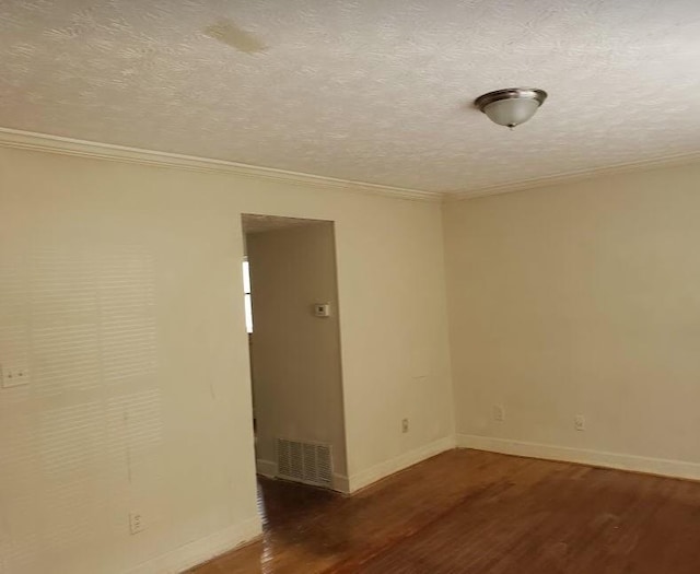 spare room with baseboards, a textured ceiling, visible vents, and wood finished floors