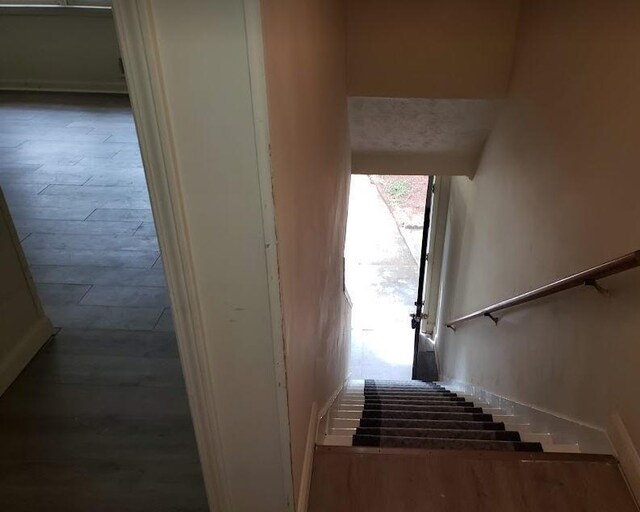 hallway with sink, dark wood-type flooring, a textured ceiling, and ornamental molding