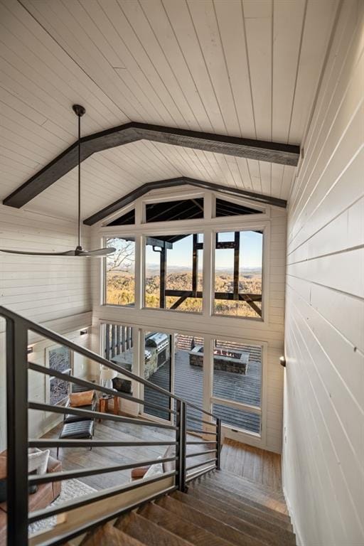 stairway with vaulted ceiling with beams, hardwood / wood-style floors, and a healthy amount of sunlight