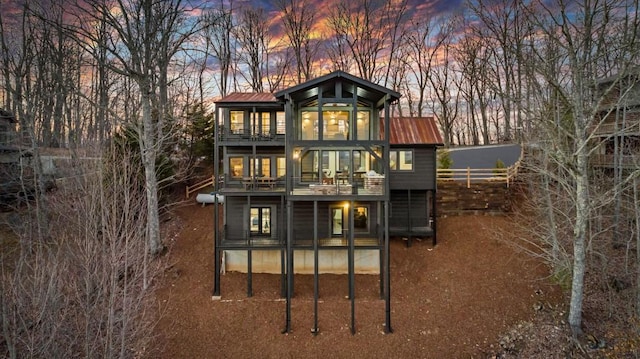 back house at dusk with a balcony