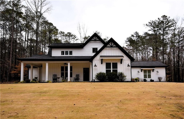 modern farmhouse featuring a porch, board and batten siding, ceiling fan, and a front lawn