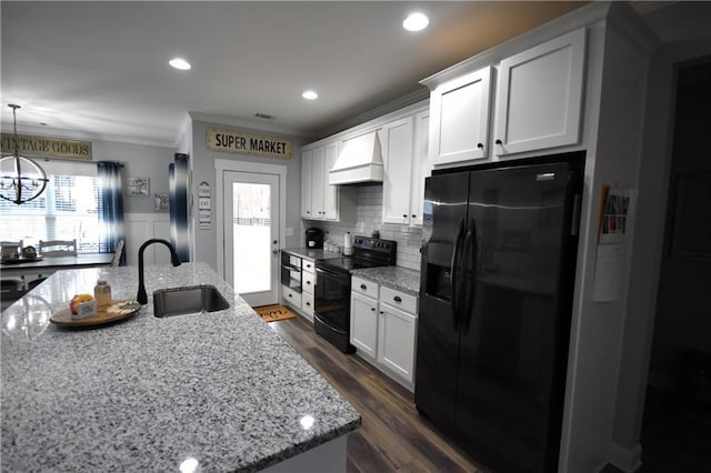 kitchen featuring black appliances, ornamental molding, custom range hood, a sink, and white cabinetry