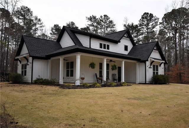 view of front of house featuring a front lawn, a porch, a ceiling fan, and roof with shingles