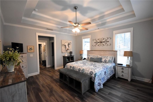 bedroom featuring dark wood-style floors, multiple windows, and a raised ceiling