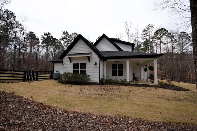 view of front of house featuring fence, roof with shingles, and ceiling fan