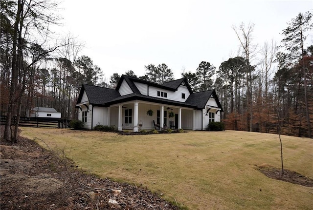 view of front of property featuring a porch, a ceiling fan, a front yard, and fence