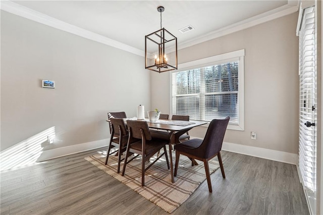 dining room featuring a notable chandelier, ornamental molding, and dark hardwood / wood-style floors