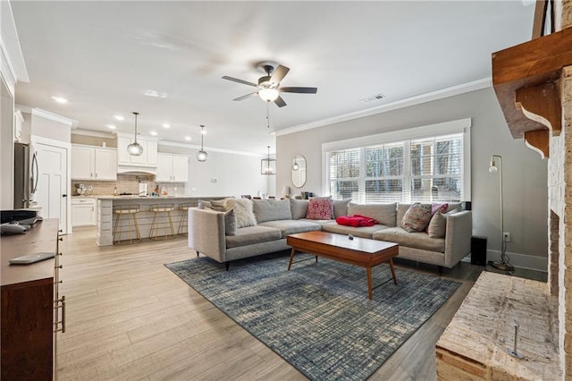 living room with ceiling fan, light hardwood / wood-style floors, and crown molding