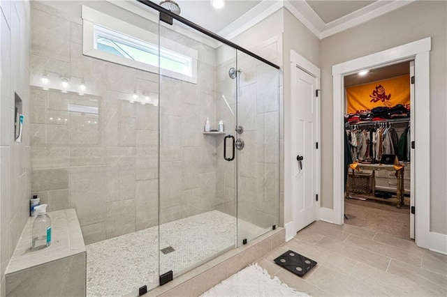 bathroom featuring tile patterned floors, ornamental molding, and a shower with shower door