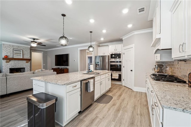 kitchen with white cabinets, pendant lighting, an island with sink, and appliances with stainless steel finishes