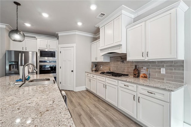 kitchen featuring stainless steel appliances, sink, decorative light fixtures, white cabinetry, and custom exhaust hood