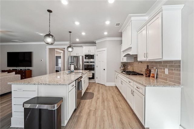 kitchen with sink, decorative light fixtures, white cabinets, a spacious island, and appliances with stainless steel finishes