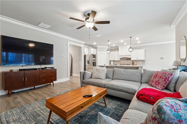 living room featuring ceiling fan, hardwood / wood-style floors, and crown molding