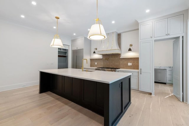 kitchen featuring decorative light fixtures, light hardwood / wood-style flooring, custom range hood, backsplash, and white cabinets