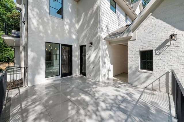 rear view of house featuring a balcony and a patio area