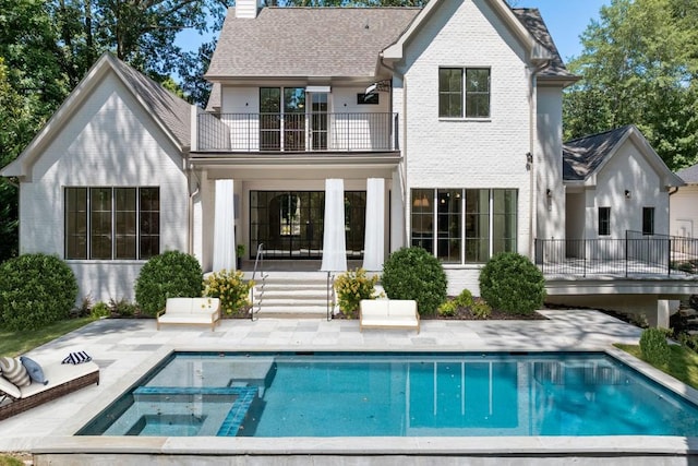 rear view of property with a balcony and a patio area