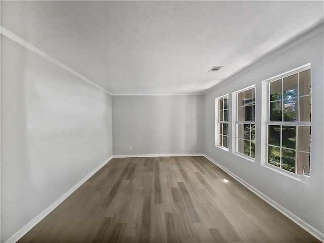 empty room featuring hardwood / wood-style floors and crown molding