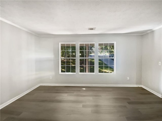 spare room with ornamental molding and dark wood-type flooring