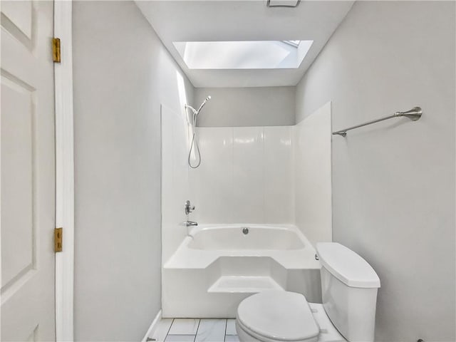 bathroom featuring toilet, a skylight, shower / washtub combination, and tile patterned flooring