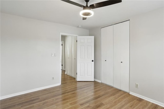 unfurnished bedroom with light hardwood / wood-style floors, ceiling fan, and a closet