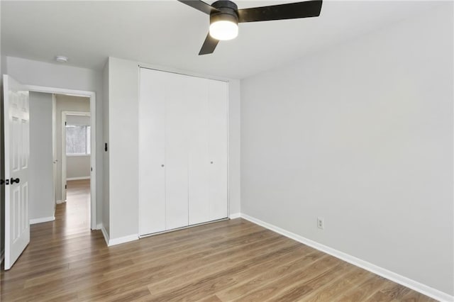 unfurnished bedroom with hardwood / wood-style flooring, a closet, and ceiling fan